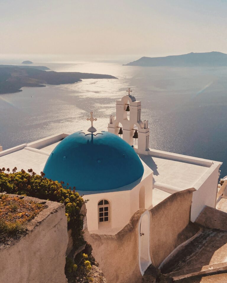 Blauwe koepelkerk op Santorini met uitzicht over de Egeische Zee